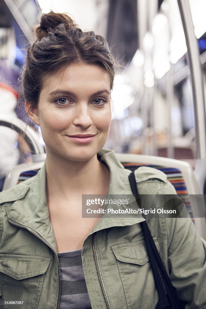 Young woman riding subway train, portrait