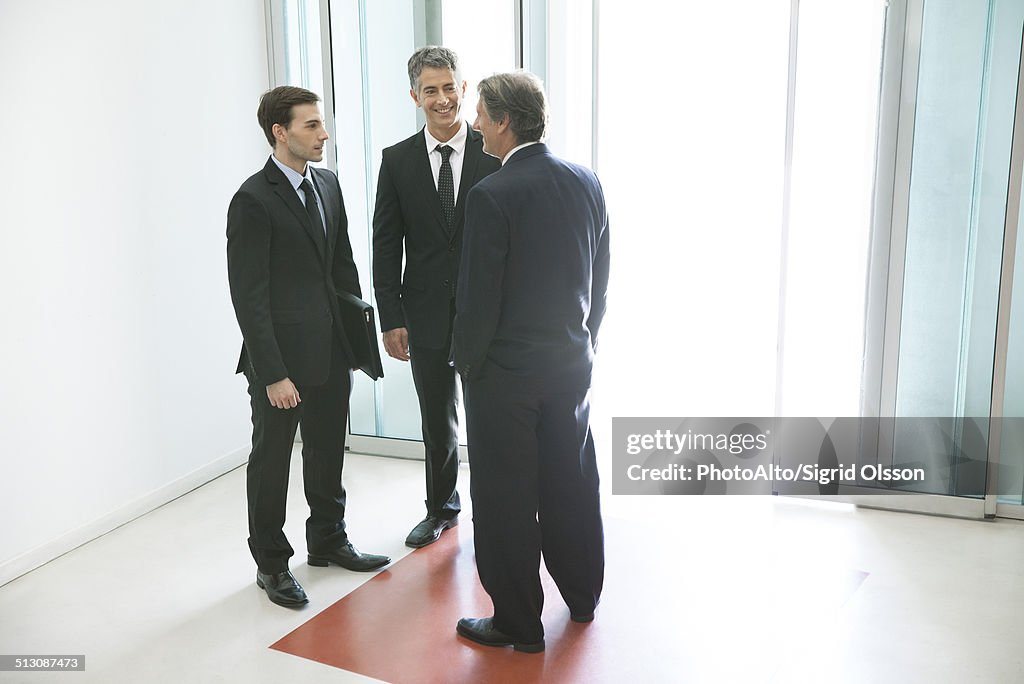 Businessmen chatting in office building lobby