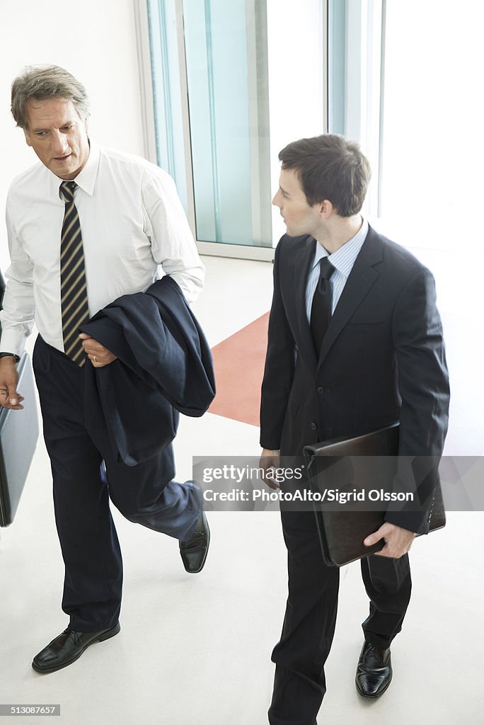 Business associates chatting while entering office building together