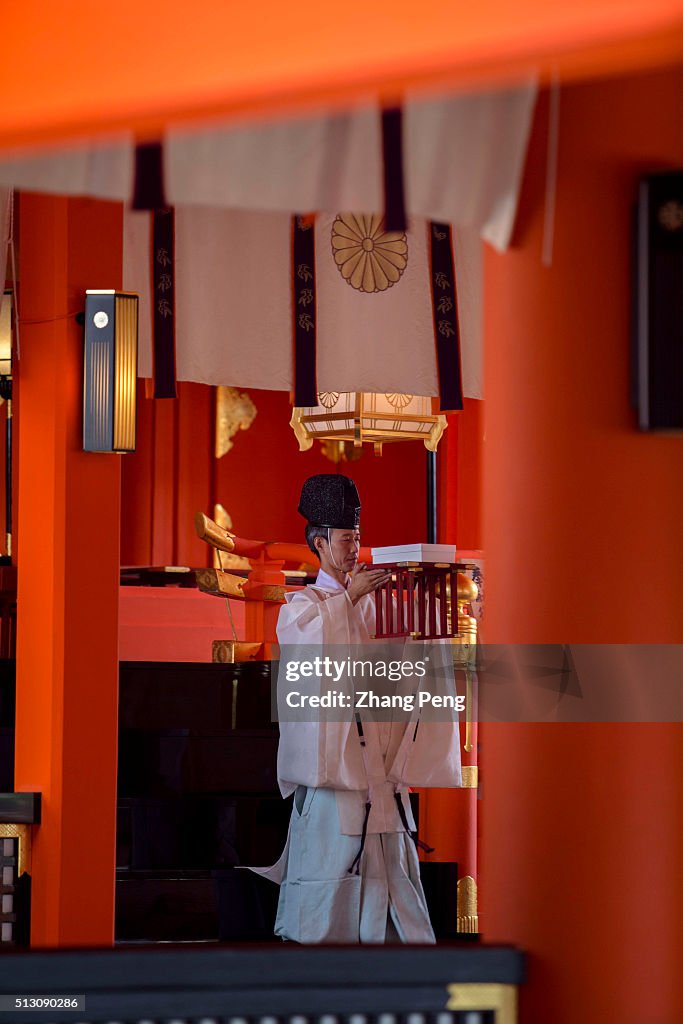 A Shinto staff is doing traditional ritual for prayers. Fushimi Inari ...