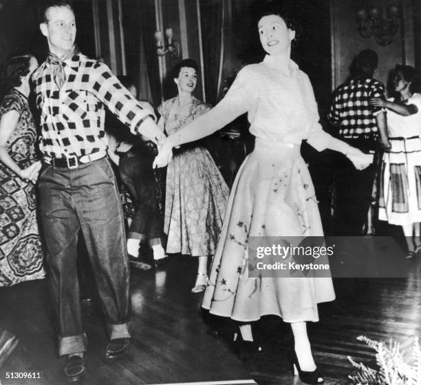 The Duke of Edinburgh dances with his wife, Princess Elizabeth, at a square dance held in their honour in Ottawa, by Governor General Viscount...