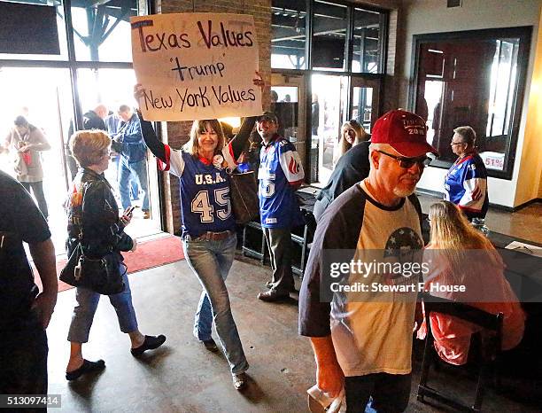 Kristi Lisenbee of Keller, Texas, hoists up a sign while entering the building as Republican presidential candidate Sen. Ted Cruz holds a rally at...