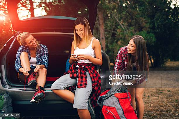 young women preparing for hike and camping in forest. - alleen jonge vrouwen stockfoto's en -beelden
