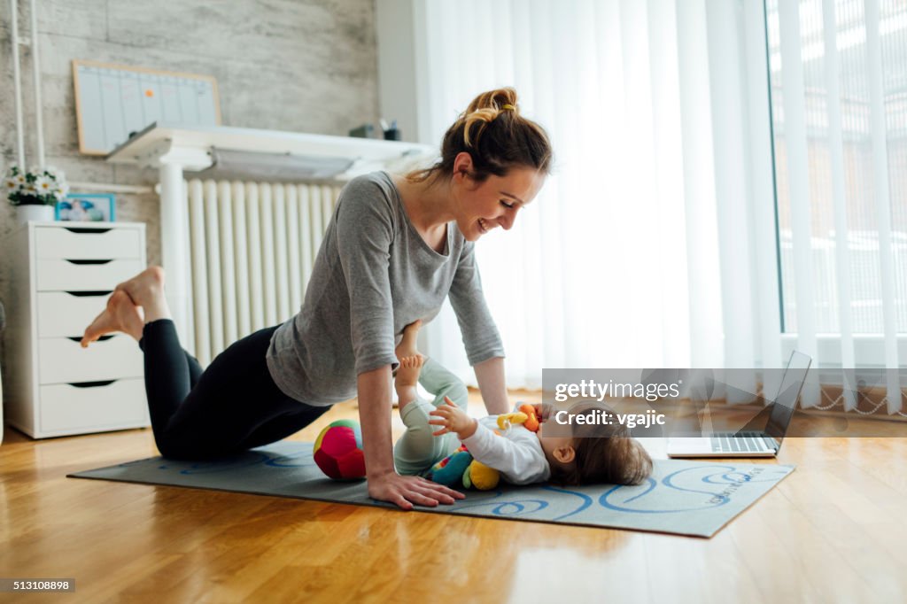 Mother Exercise With Her Baby At Home