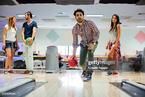 junger mann bowling mit seinen freunden. - bowler hat stock-fotos und bilder