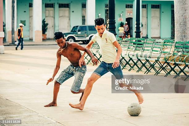 cuban boys playing soccer in the street - street-urchin stock pictures, royalty-free photos & images