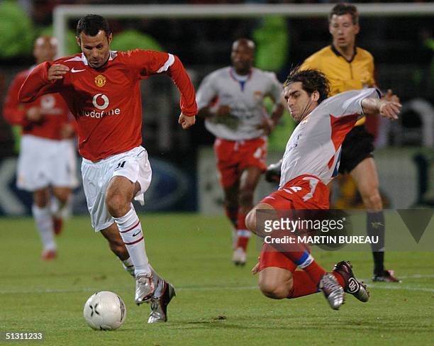 Manchester United's forward Welsh Ryan Giggs is tackled by Lyon's midfielder Brazilian Pernambucano Juninho, 15 September 2004 at Gerland stadium in...