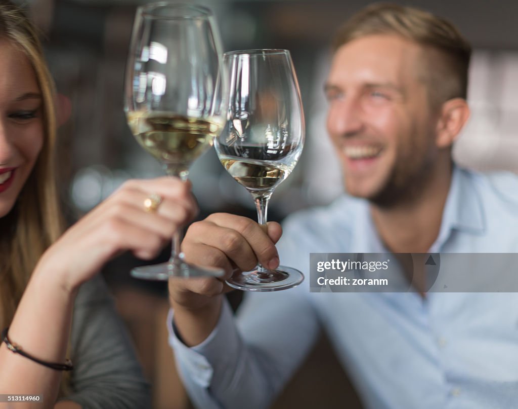 Paar beim Anstoßen mit Weißwein