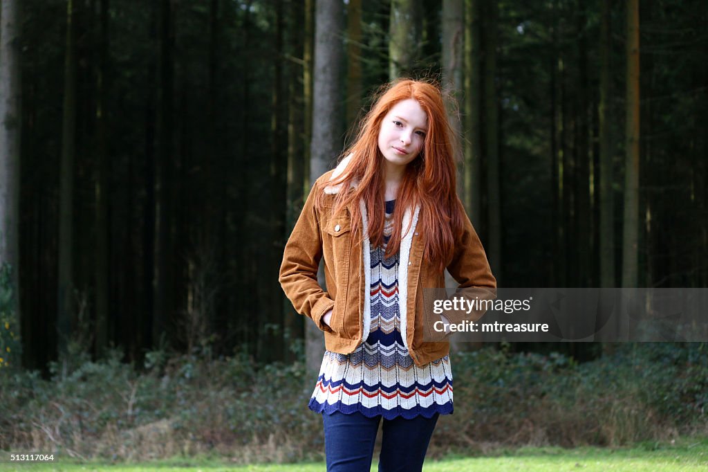 Image of attractive girl, long red hair, hands in pockets