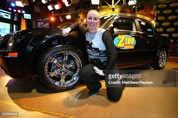 Contest Winner Melissa Kennedy of Mahopac, New York, poses with her new Chrysler 300 sedan as part of the Z100 Pimp My Summer Contest at Times Square...