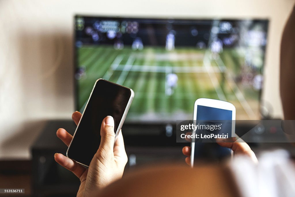 Freunden mit Handy während des tennis-match