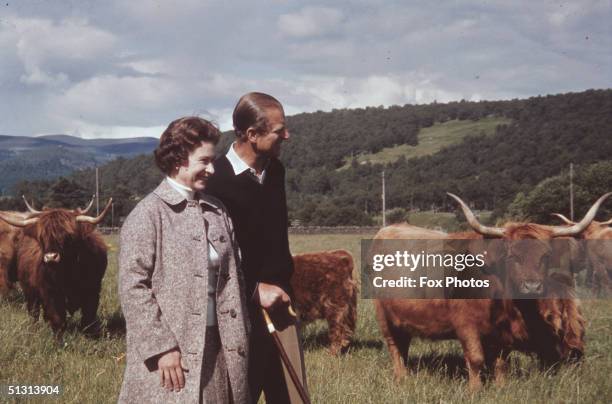 Queen Elizabeth II and Prince Philip in a field with some highland cattle at Balmoral, Scotland, 1972.