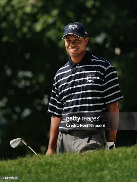 Team player Tiger Woods smiles as he looks over the 11th green during the final practice day for the 35th Ryder Cup Matches at the Oakland Hills...