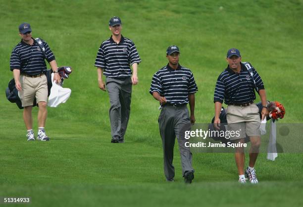 Team players Tiger Woods and Chris Riley walks off the 12th tee with their caddies during the final practice day for the 35th Ryder Cup Matches at...