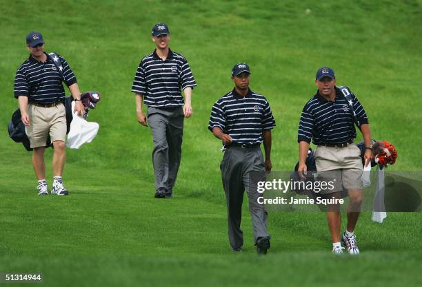 Team players Tiger Woods and Chris Riley walks off the 12th tee with their caddies during the final practice day for the 35th Ryder Cup Matches at...