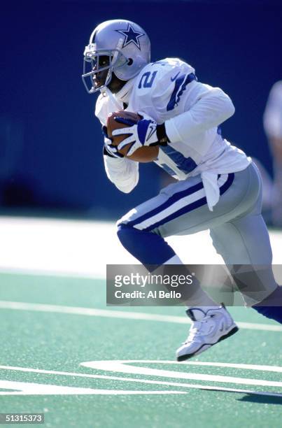 Deion Sanders of the Dallas Cowboys runs with the ball during a game against the New York Giants at Giants Stadium on October 4, 1997 in East...