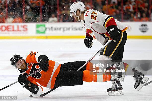 Claude Giroux of the Philadelphia Flyers gets tripped up by the stick of Dougie Hamilton of the Calgary Flames during the second period at Wells...