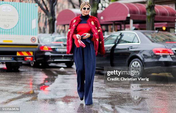 Thassia Naves is wearing a red fur jacket and a navy jumpsuit seen outside Giorgio Armani during Milan Fashion Week Fall/Winter 2016/17 on February...