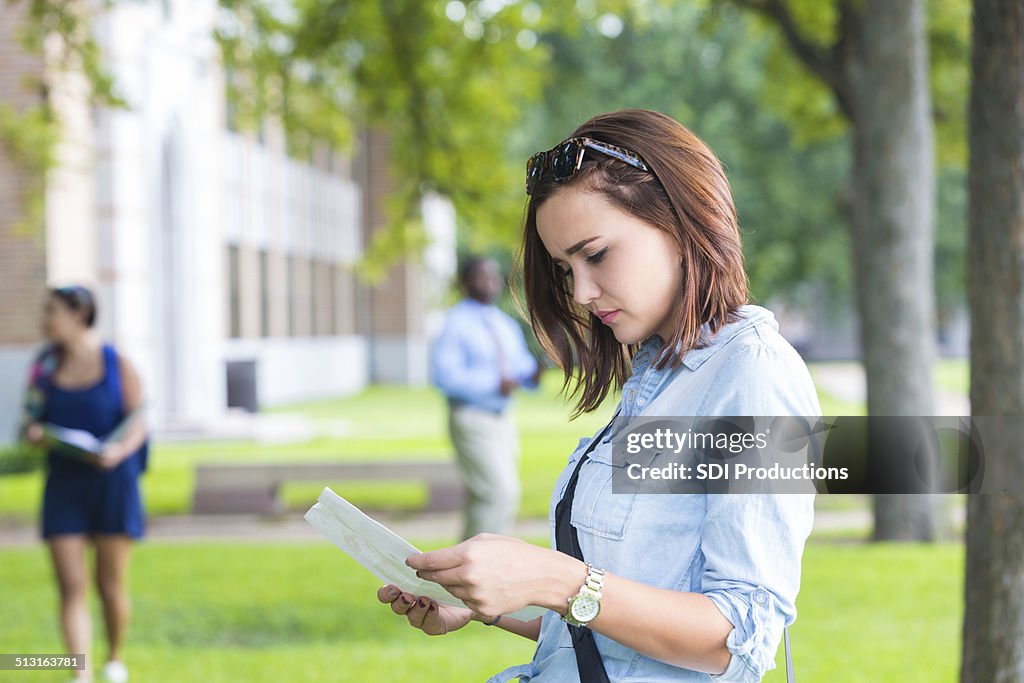 Young college student studying class schedule or campus map