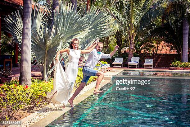 bride and groom jumping in the pool - fall bouquet stock pictures, royalty-free photos & images