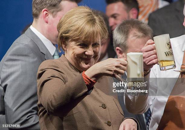 Angela Merkel, Germany's chancellor, holds a stein glass of beer during a Christian Democratic Party local election campaign rally in Volkmarsen,...