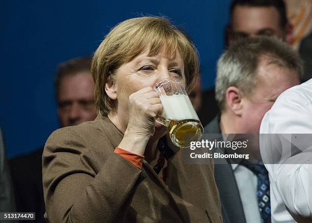 Angela Merkel, Germany's chancellor, drinks from a stein glass of beer during a Christian Democratic Party local election campaign rally in...