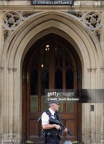 An armed police officer stands guard outside of an entrance to Britain's Houses of Parliament on September 17, 2004 in London, England. Britain's...