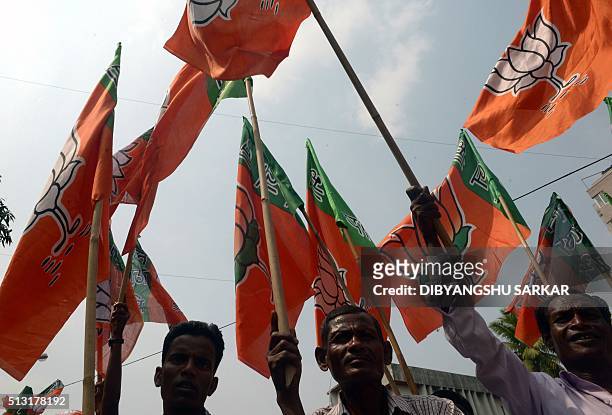 Activists of the Bhartiya Janata Party wave party flags during a protest march against the state government in Kolkata on March 1, 2016. Hundreds of...