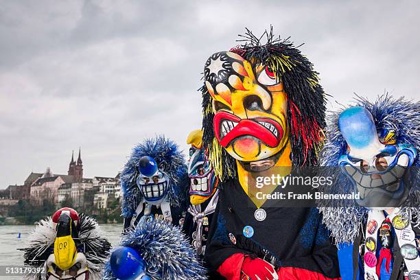 Many different groups of masked people walk through the streets of Basel for 3 days and nights at Basler Fasnacht, playing music all the time.