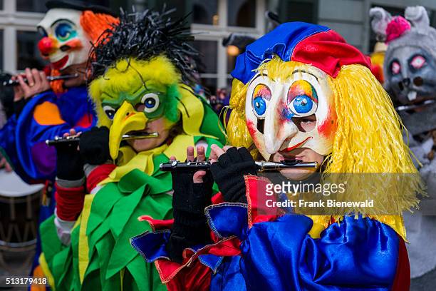 Many different groups of masked people walk through the streets of Basel for 3 days and nights at Basler Fasnacht, playing music all the time.