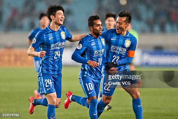Alex Teixeira of Jiangsu Suning celebrates with team mates after scoring his team's first goal during the AFC Champions League Group E match between...