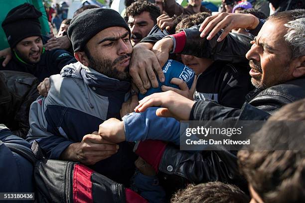 Refugees scrabble amongst each other as they stage a protest along the Greek-Macedonia border on March 01, 2016 near Idomeni, Greece. The transit...