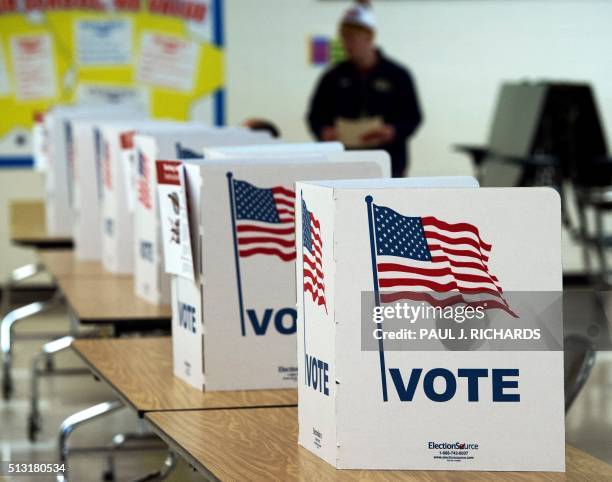 Man walks to use a voting booth March 1 at one of the Virginia primary election polling stations at Colin Powell Elementary School, in Centreville,...