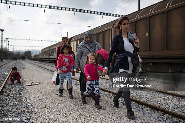 Families walk along train tracks as refugees continue to arrive at the Greek-Macedonia border on March 01, 2016 near Idomeni, Greece. The transit...