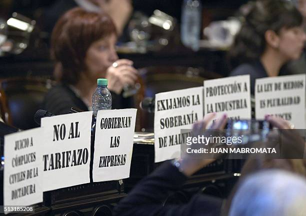 An oposition legislator takes a snap of the placards with legends against Argentine President Mauricio Macri during the inauguration of the 134th...