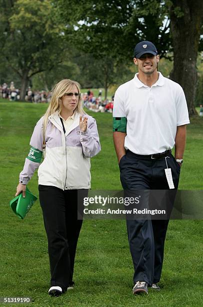 Caroline Harrington walks with Padraig's second cousin Joey Harrington of the Detroit Lions football team during the afternoon foursome matches at...