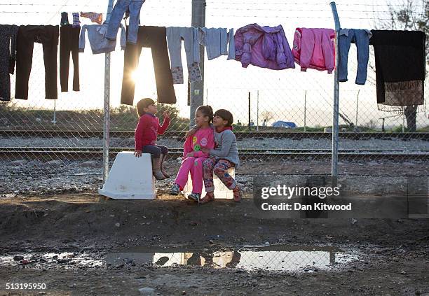 Children play as clothes dry on a fence at the Greek-Macedonia border on March 01, 2016 near Idomeni, Greece. The transit camp has become overcrowded...