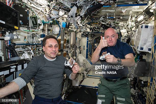 In this handout photo provided by NASA, NASA astronaut Scott Kelly gives a thumbs up on the quality of his snack while taking a break from his work...