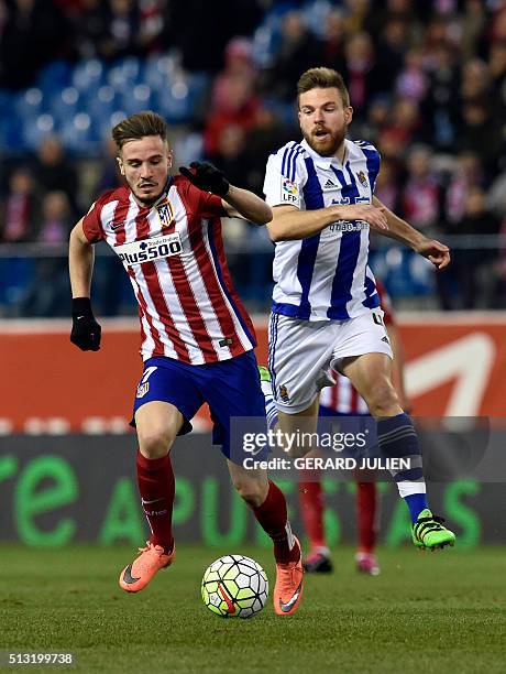 Atletico Madrid's midfielder Saul Niguez vies with Real Sociedad's midfielder Asier Illarramendi during the Spanish league football match Club...