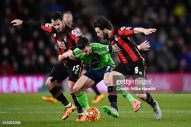 Shane Long of Southampton competes for the ball against Adam Smith and Harry Arter of Bournemouth during the Barclays Premier League match between...