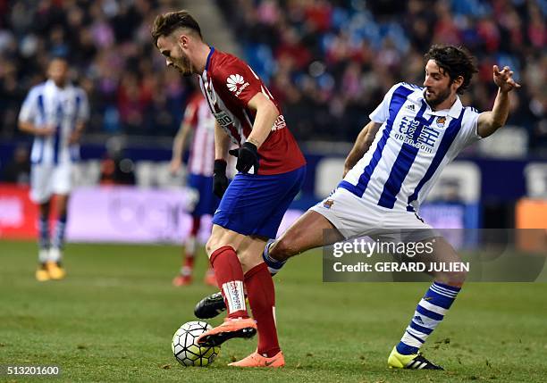 Atletico Madrid's midfielder Saul Niguez vies with Real Sociedad's midfielder Esteban Granero during the Spanish league football match Club Atletico...