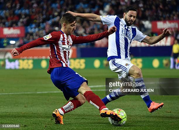Atletico Madrid's Argentinian forward Luciano Vietto vies with Real Sociedad's midfielder Asier Illarramendi during the Spanish league football match...