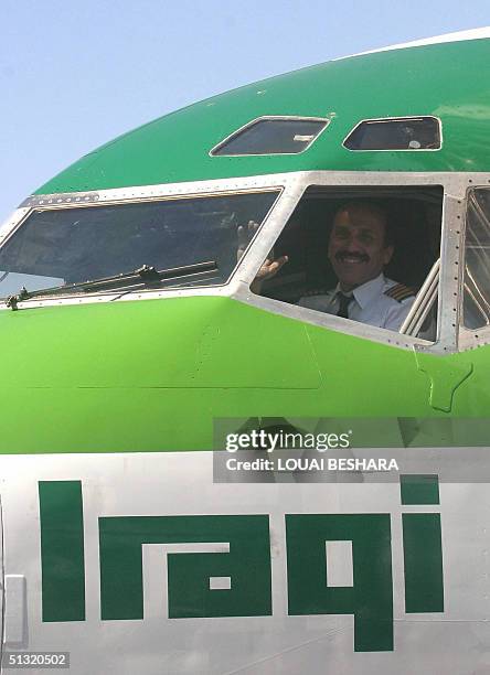 The unidentified pilot waves to photographers after landing an Iraqi Airways Boeing 737 on its first flight from Baghdad at Damascus international...