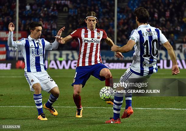 Atletico Madrid's Brazilian defender Filipe Luis vies with Real Sociedad's defender Capilla and Real Sociedad's midfielder Xabier Prieto during the...