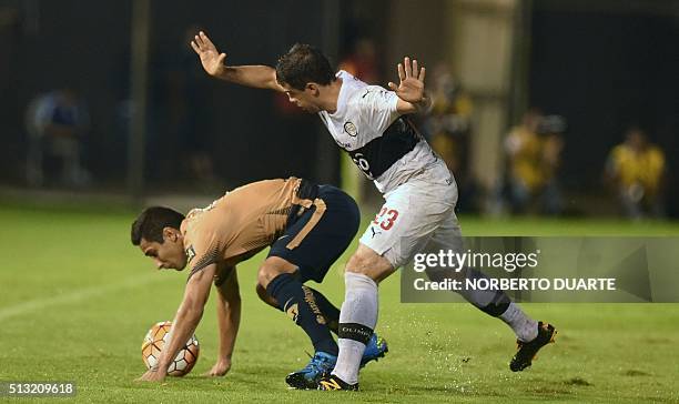 Luis Fuentes of Mexico's Pumas vies for the ball with Julian Benitez of Paraguay's Olimpia during their 2016 Libertadores Cup football match at...
