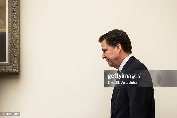 Director James Comey enters the chambers for a House Judiciary Committee Hearing on Apple's denial of the FBI's request to provide a way to hack into...