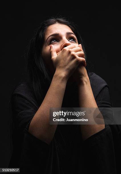 hispanic immigrant looking up with fear - christianity black background stock pictures, royalty-free photos & images