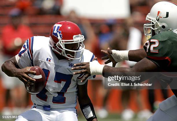 Quarterback Donald Allen of Louisiana Tech dodges defensive linemen Orien Harris of the University of Miami in the first quarter on September 18,...