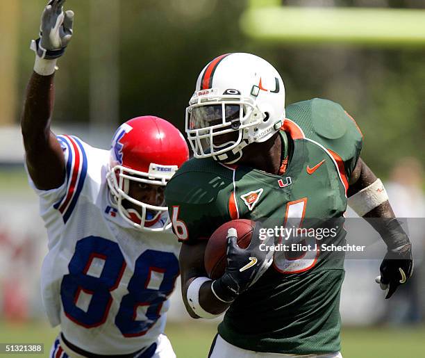 Defensive back Antrel Rolle of the University of Miami picks up a turnover with wide receiver Tramissian Davis of Louisiana Tech in pursuit on...