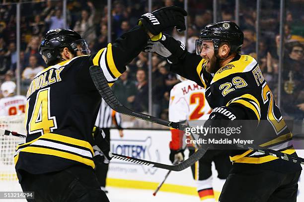 Brett Connolly of the Boston Bruins congratulates Landon Ferraro after he scored against the Calgary Flames during the first period at TD Garden on...